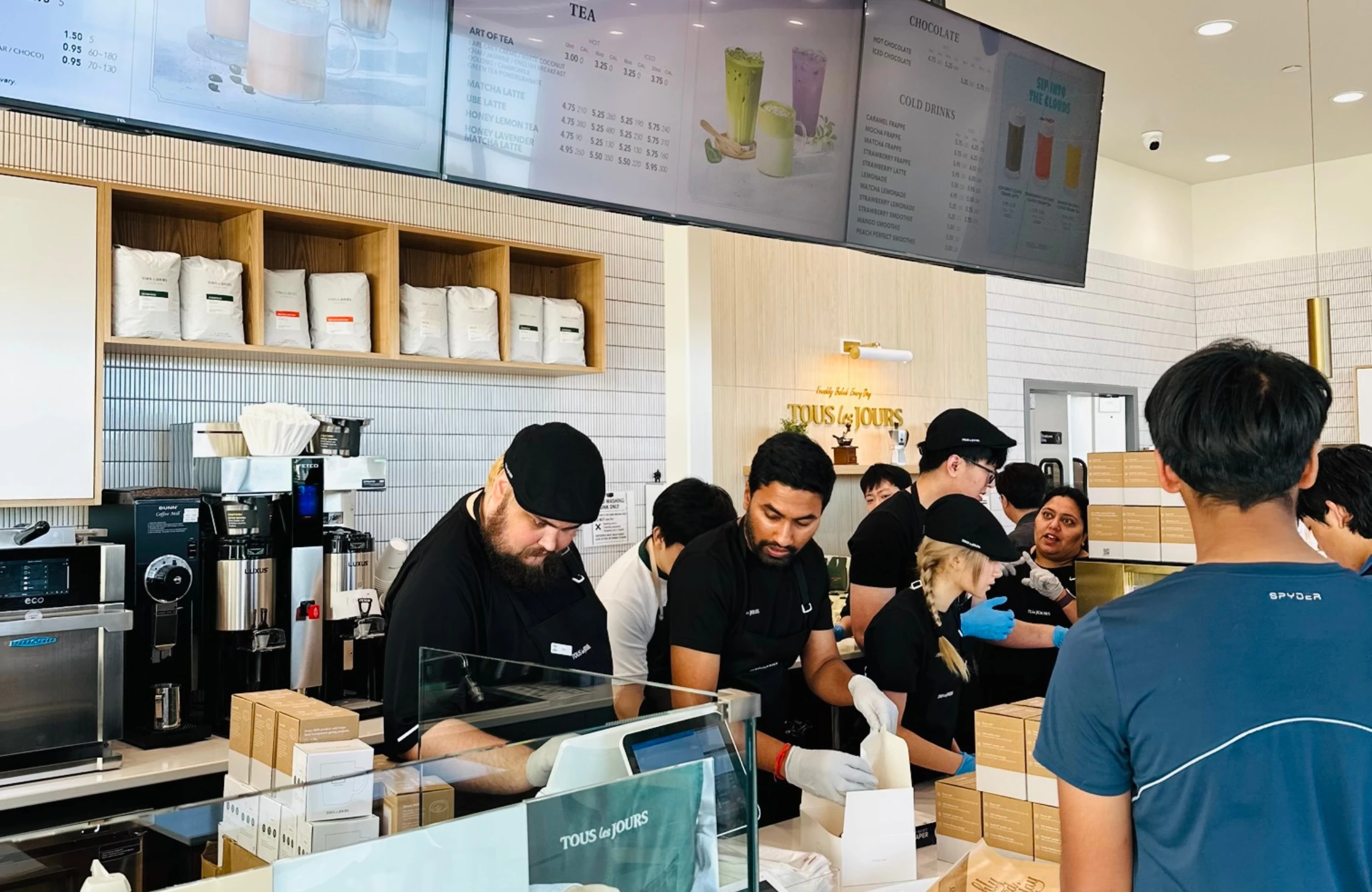 Friendly staff serving customers at TOUS les JOURS bakery café, highlighting the lively ambiance and service quality – one of the Top 10 Reasons TOUS les JOURS Is the Ideal Brunch Spot in Iowa
