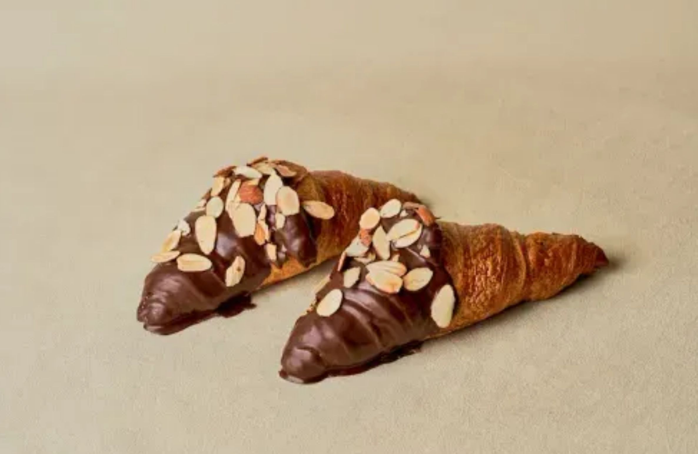 Chocolate almond croissants with sliced almonds and rich chocolate glaze at Tous Les Jours Iowa – best Korean desserts in Iowa.